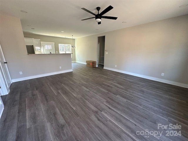 unfurnished living room featuring ceiling fan and dark hardwood / wood-style floors