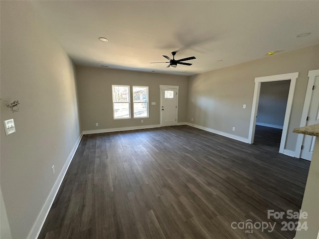 spare room featuring ceiling fan and dark wood-type flooring