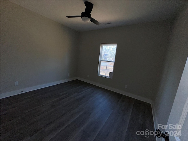 empty room with ceiling fan and dark wood-type flooring