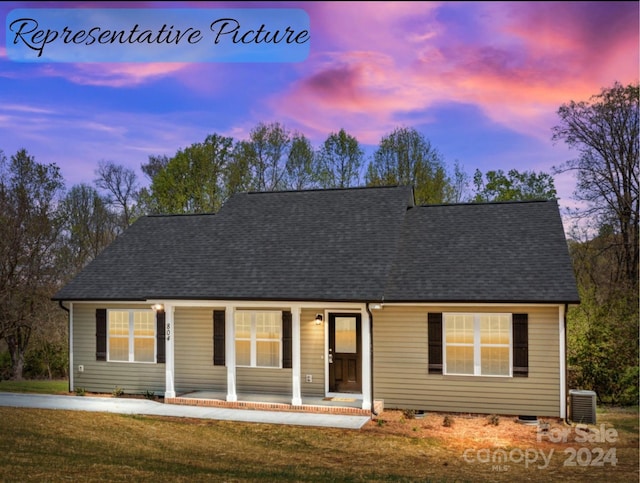 view of front of property featuring central air condition unit and a lawn