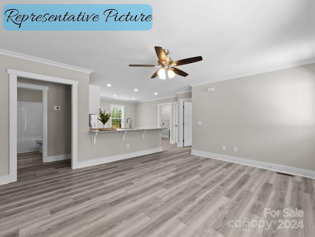 unfurnished living room with ceiling fan, light wood-type flooring, crown molding, and sink