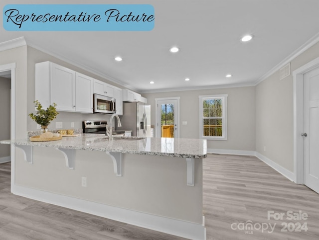 kitchen featuring appliances with stainless steel finishes, light stone countertops, light hardwood / wood-style floors, and white cabinets