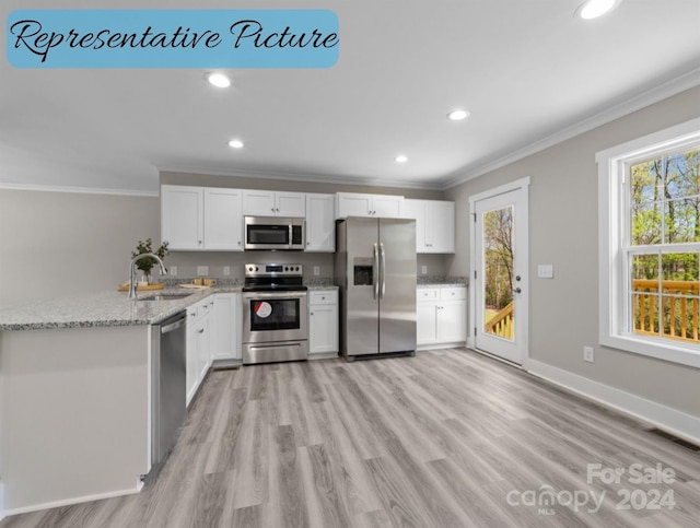 kitchen featuring sink, white cabinetry, appliances with stainless steel finishes, light stone countertops, and light hardwood / wood-style floors