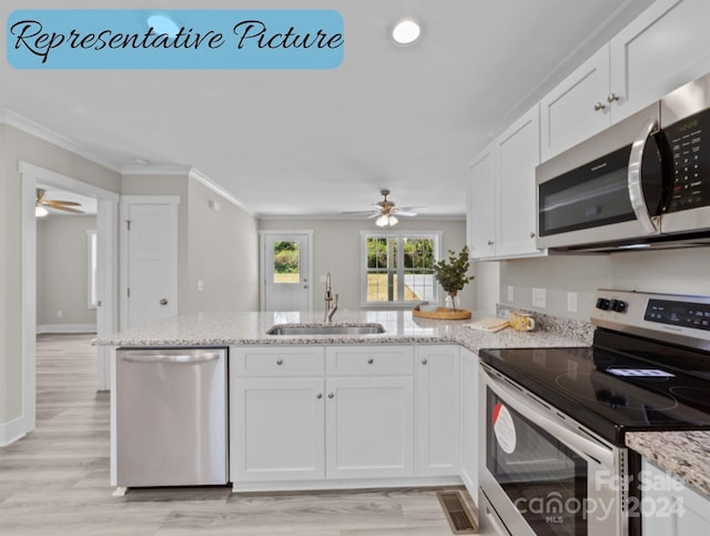 kitchen featuring light wood-type flooring, white cabinets, sink, ornamental molding, and appliances with stainless steel finishes