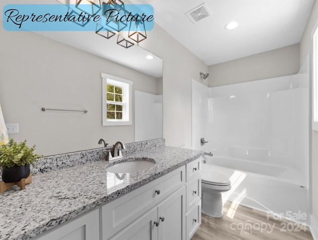 full bathroom featuring shower / bathtub combination, hardwood / wood-style floors, vanity, and toilet