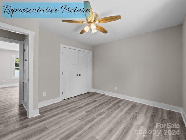 unfurnished bedroom featuring light wood-type flooring, ceiling fan, and a closet