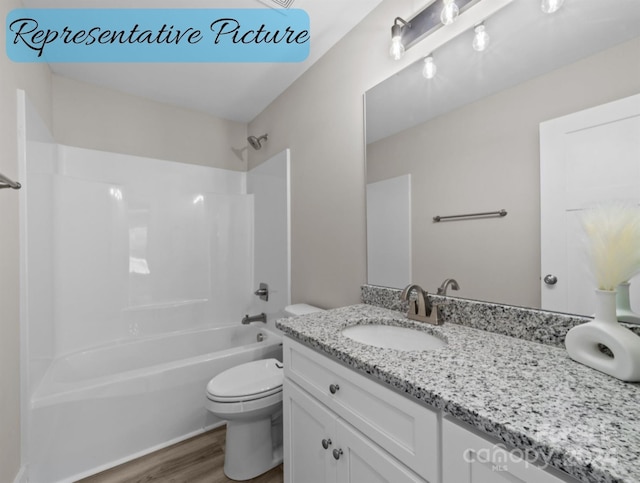 full bathroom with tub / shower combination, hardwood / wood-style floors, vanity, and toilet