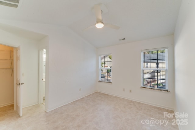 unfurnished bedroom featuring visible vents, lofted ceiling, and multiple windows