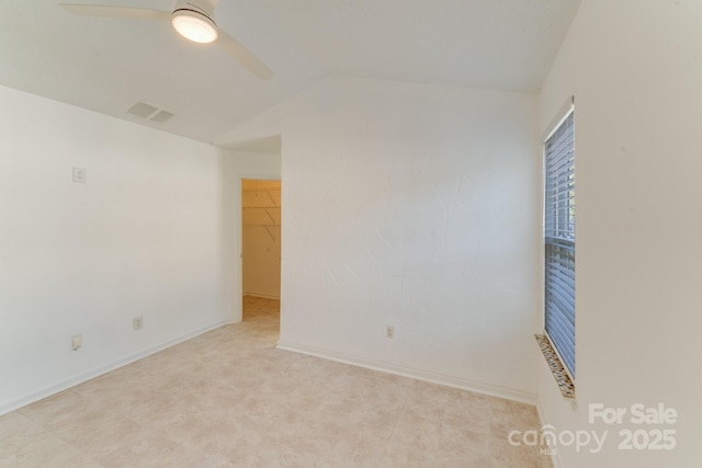 spare room with visible vents, lofted ceiling, baseboards, and ceiling fan