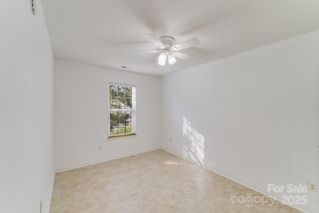 empty room with a textured ceiling and ceiling fan