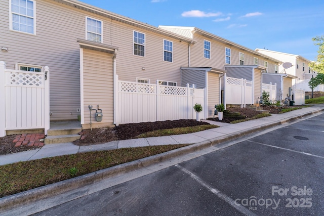 view of front of property featuring a residential view and fence