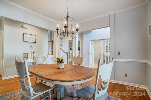 dining room with crown molding, a chandelier, and hardwood / wood-style flooring