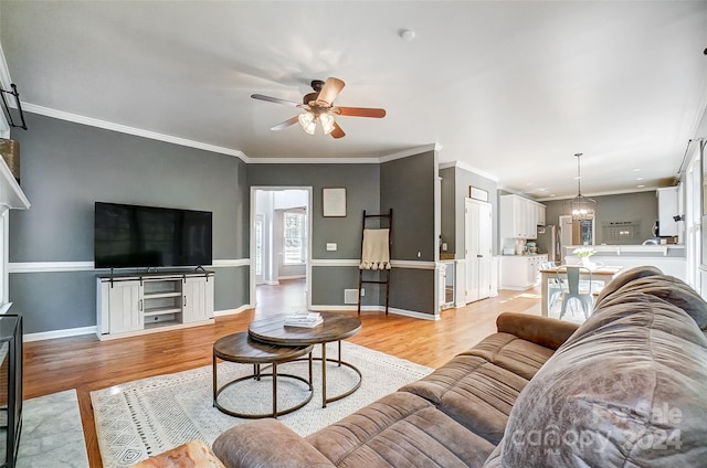 living room with ceiling fan, light wood-type flooring, and ornamental molding