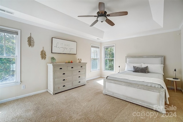 bedroom with ceiling fan, light colored carpet, a raised ceiling, and multiple windows