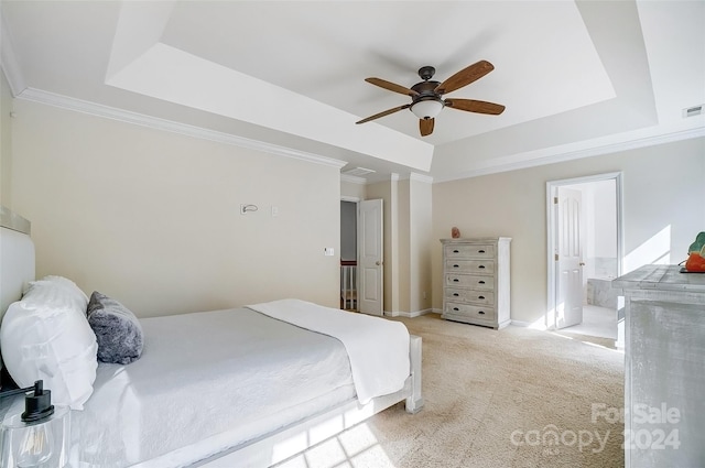 bedroom with light carpet, a tray ceiling, ensuite bath, and ceiling fan