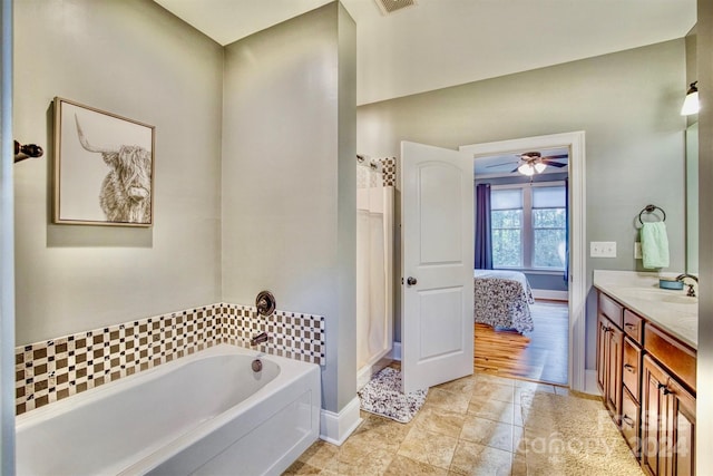 bathroom featuring hardwood / wood-style flooring, a tub to relax in, ceiling fan, and vanity