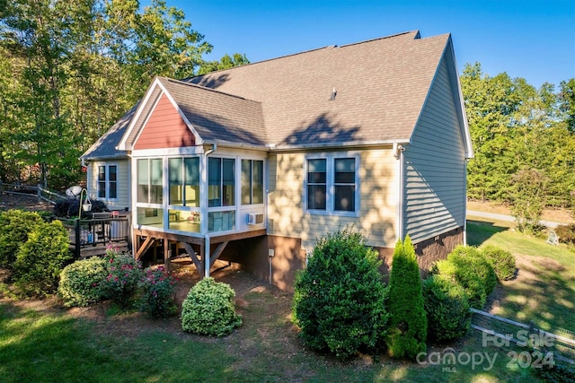 back of house with a yard, a sunroom, and a deck