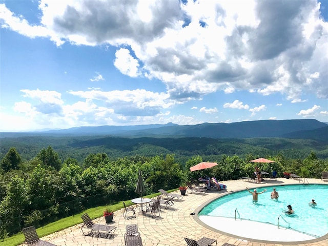 view of pool featuring a patio area and a mountain view