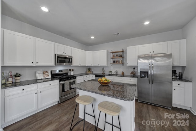 kitchen with appliances with stainless steel finishes, white cabinetry, and dark wood-type flooring