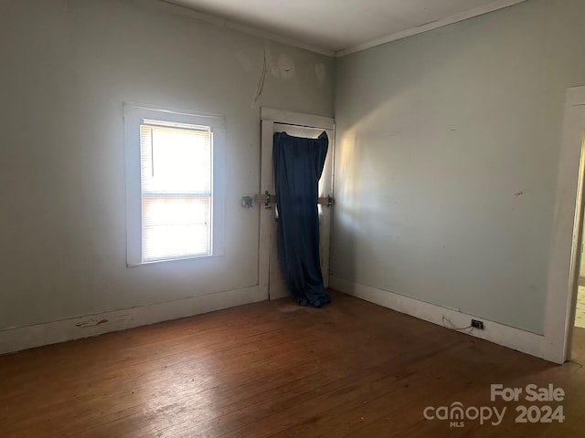 empty room with crown molding and hardwood / wood-style floors