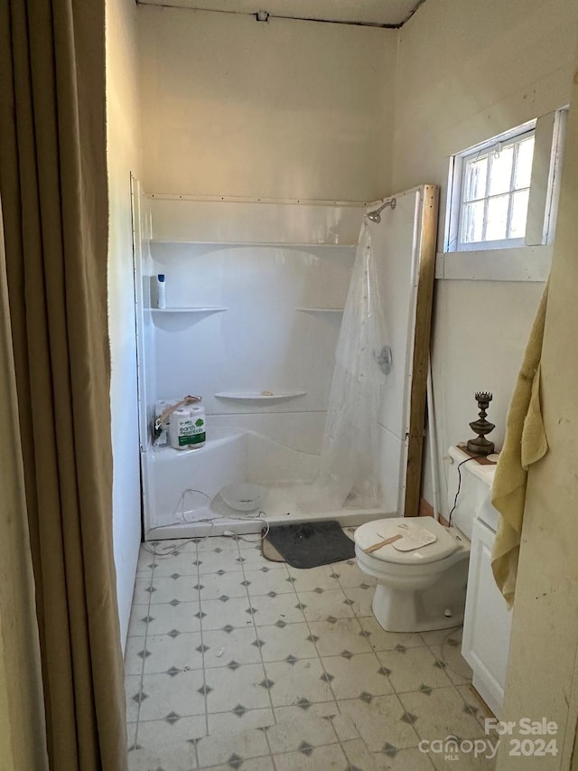 bathroom featuring toilet and a shower with curtain