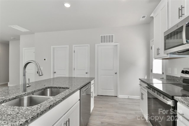 kitchen featuring sink, light hardwood / wood-style flooring, stone countertops, white cabinetry, and stainless steel appliances