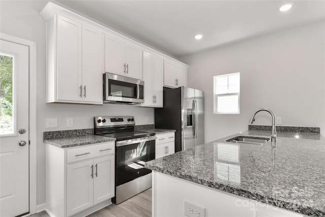 kitchen featuring kitchen peninsula, sink, white cabinets, and appliances with stainless steel finishes