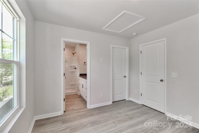 unfurnished bedroom with light hardwood / wood-style flooring and ensuite bath