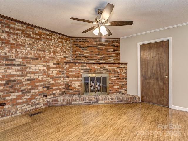 unfurnished living room with ceiling fan, light hardwood / wood-style floors, ornamental molding, and a textured ceiling