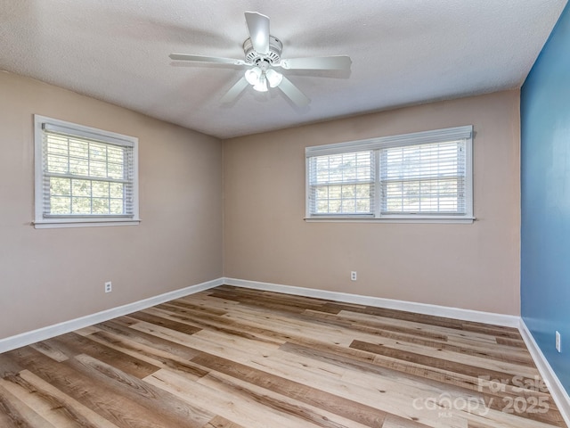 empty room featuring a textured ceiling, light hardwood / wood-style flooring, and ceiling fan