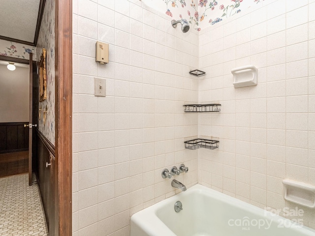 bathroom with tiled shower / bath combo, a textured ceiling, and ornamental molding