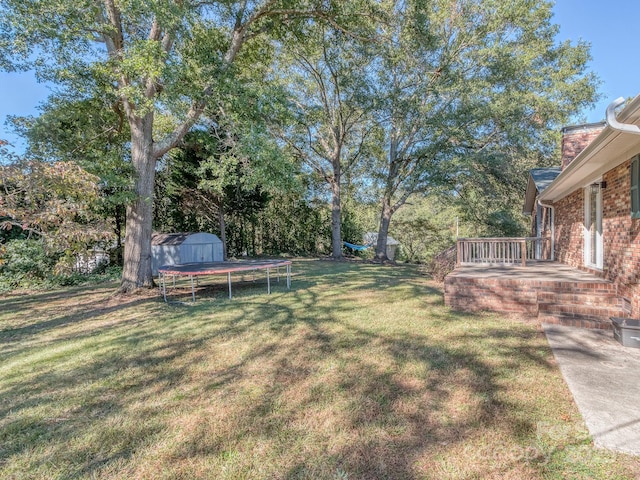 view of yard with a trampoline, a storage unit, and a patio area