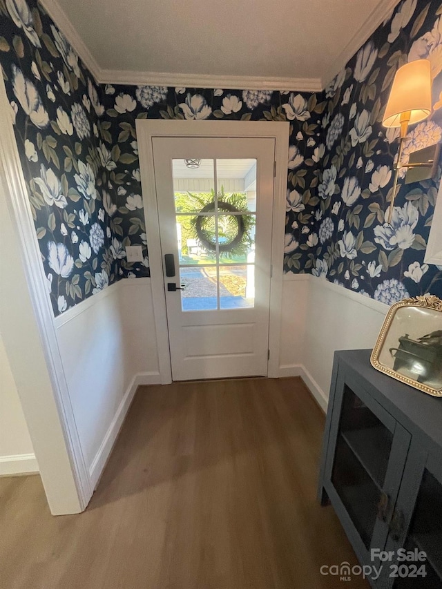 doorway to outside featuring crown molding and dark hardwood / wood-style floors