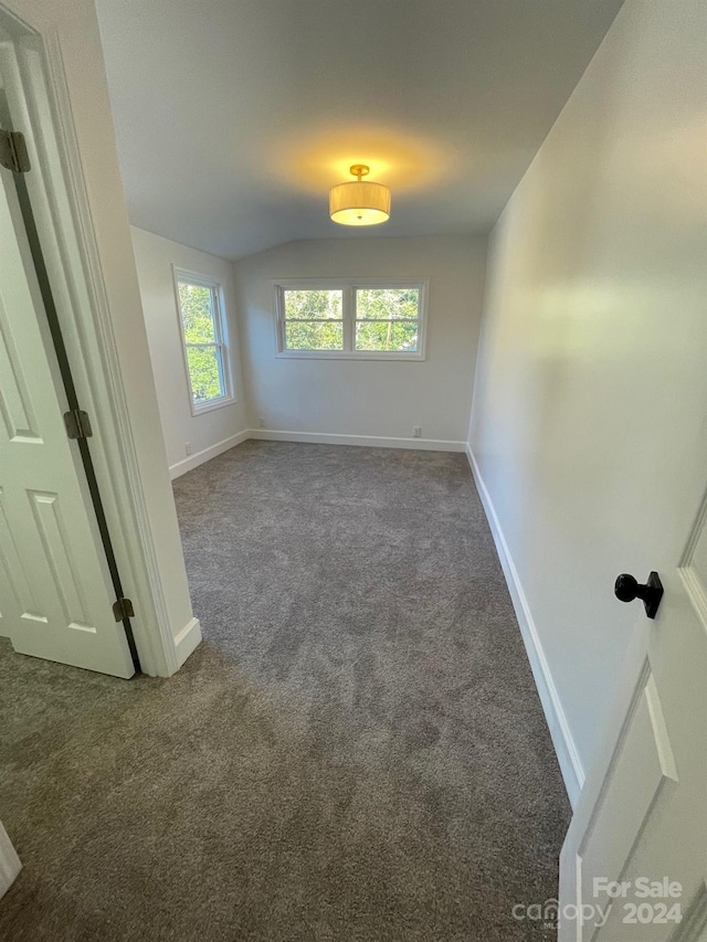 spare room with dark carpet