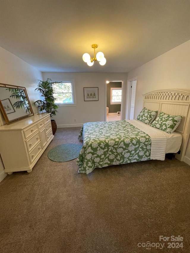 bedroom featuring dark carpet and a chandelier