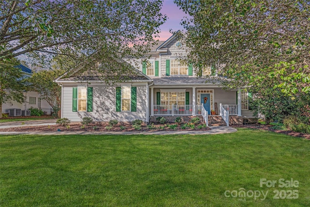 view of front of house featuring a porch, cooling unit, and a yard