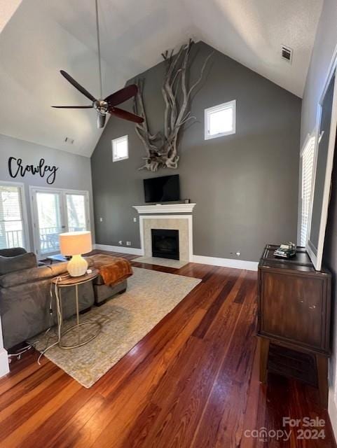 living room featuring a healthy amount of sunlight, high vaulted ceiling, ceiling fan, and dark hardwood / wood-style flooring