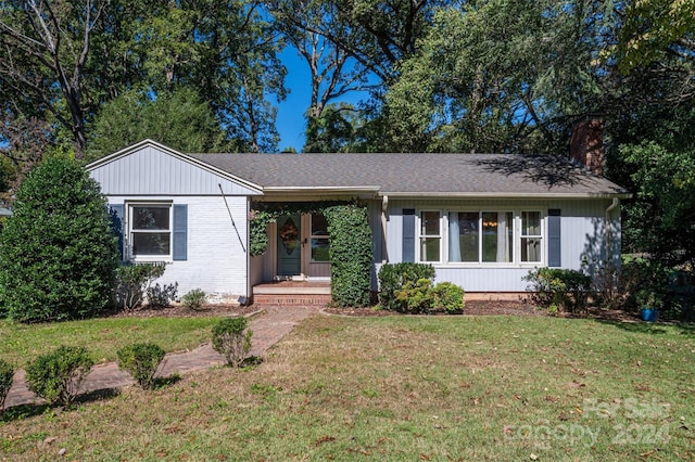 single story home with a porch and a front lawn