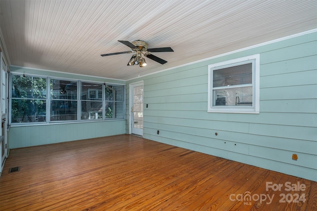 unfurnished sunroom featuring ceiling fan