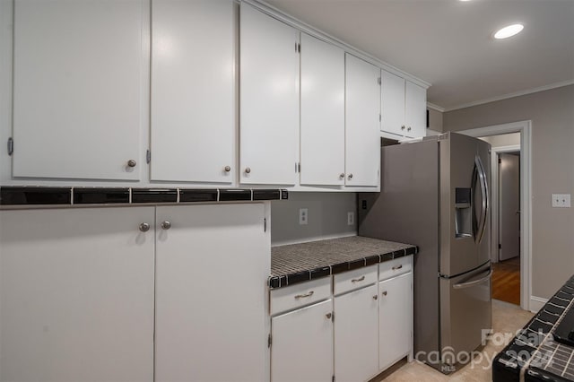 kitchen featuring crown molding, tile counters, white cabinets, and stainless steel refrigerator with ice dispenser