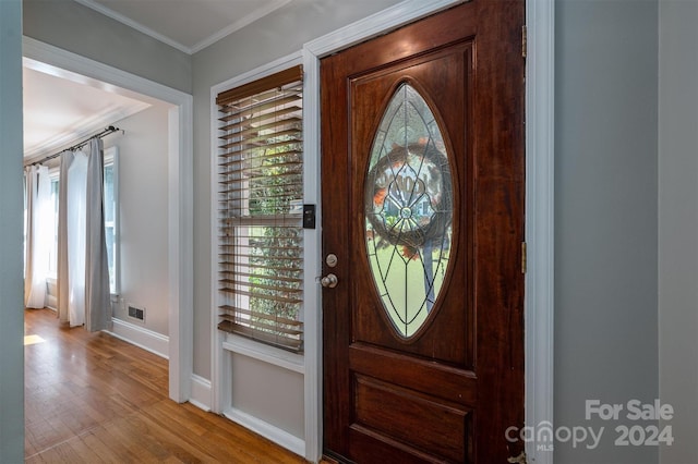 foyer entrance featuring ornamental molding and light hardwood / wood-style flooring