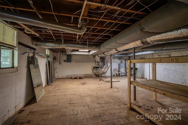 basement featuring electric panel and water heater