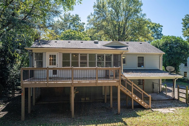 back of property with a sunroom, a deck, and a patio area