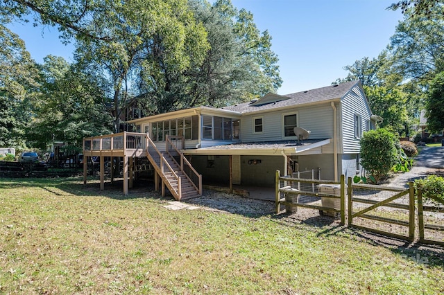 rear view of house with a sunroom, a deck, a patio, and a lawn