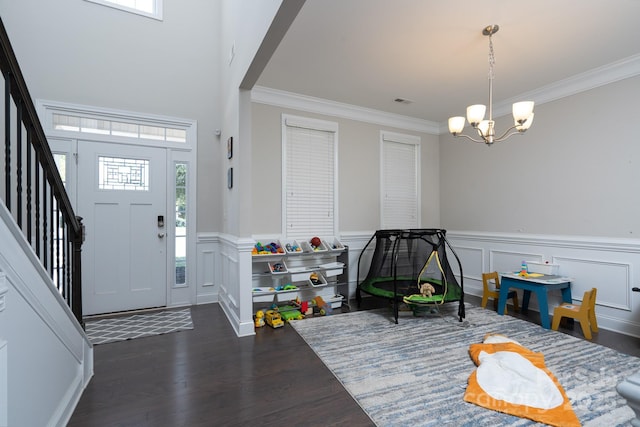 entryway featuring ornamental molding, dark hardwood / wood-style floors, plenty of natural light, and a notable chandelier