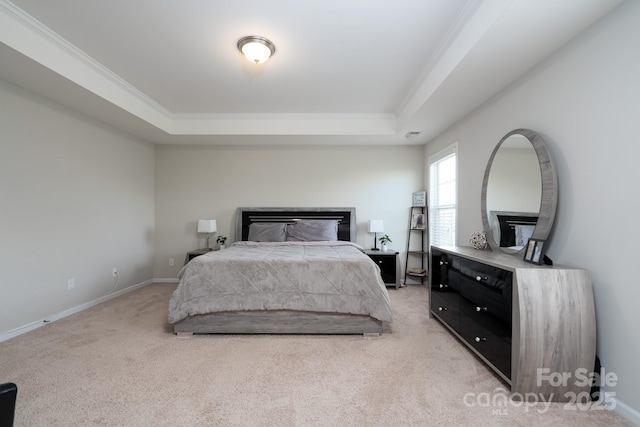 carpeted bedroom featuring ornamental molding and a tray ceiling