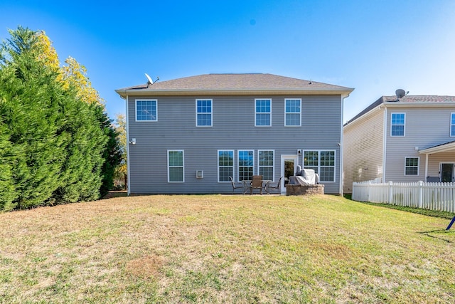 rear view of property featuring a lawn and a patio area