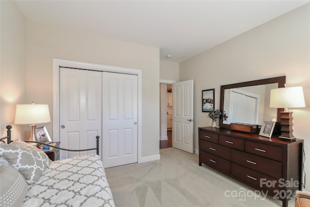 bedroom with a closet and light colored carpet