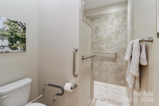 bathroom with tiled shower and toilet