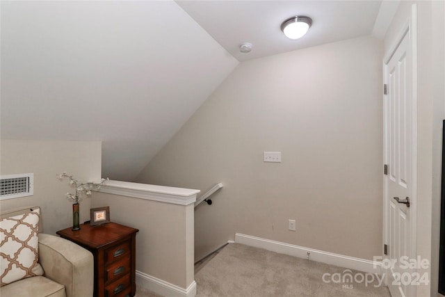 stairway featuring vaulted ceiling and carpet